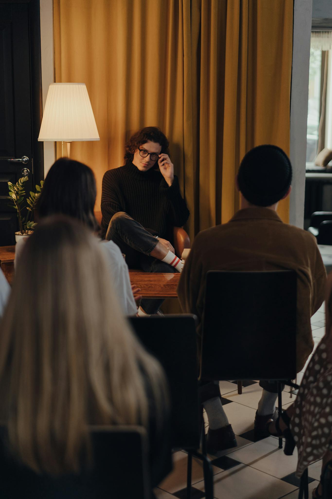 Author in a black sweater speaks to a small audience during a creative evening in a bookstore.